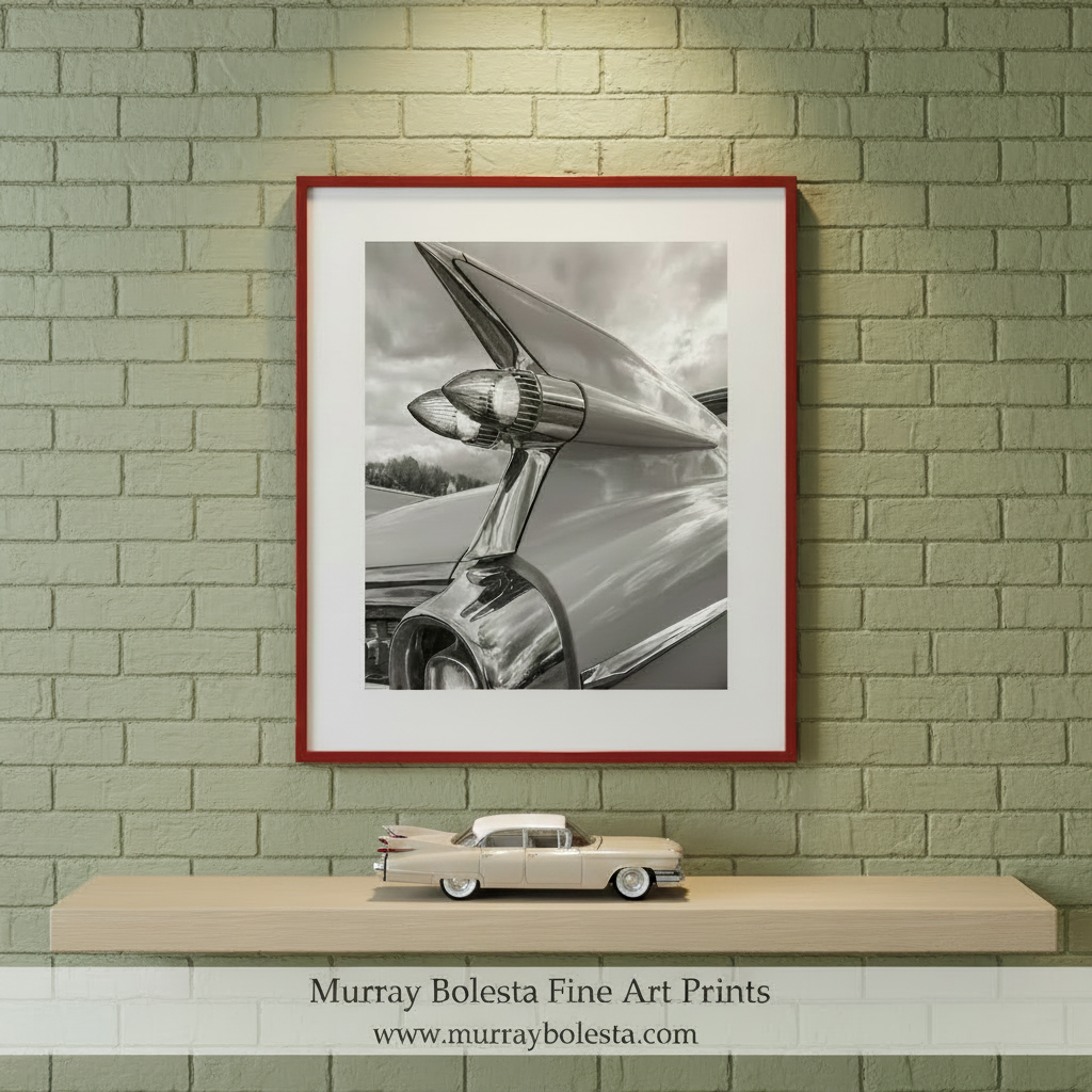 The image is a black and white photograph of a chrome car's tail fins, Cadillac Tail Fins Picture – Black & White Classic Car Art by Murray Bolesta