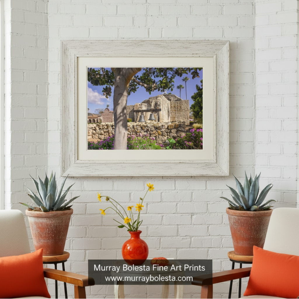 a stone church with two bells hanging from its side, surrounded by a stone wall and lush greenery. San Juan Capistrano Mission Wall Art - California Church Print by Murray Bolesta