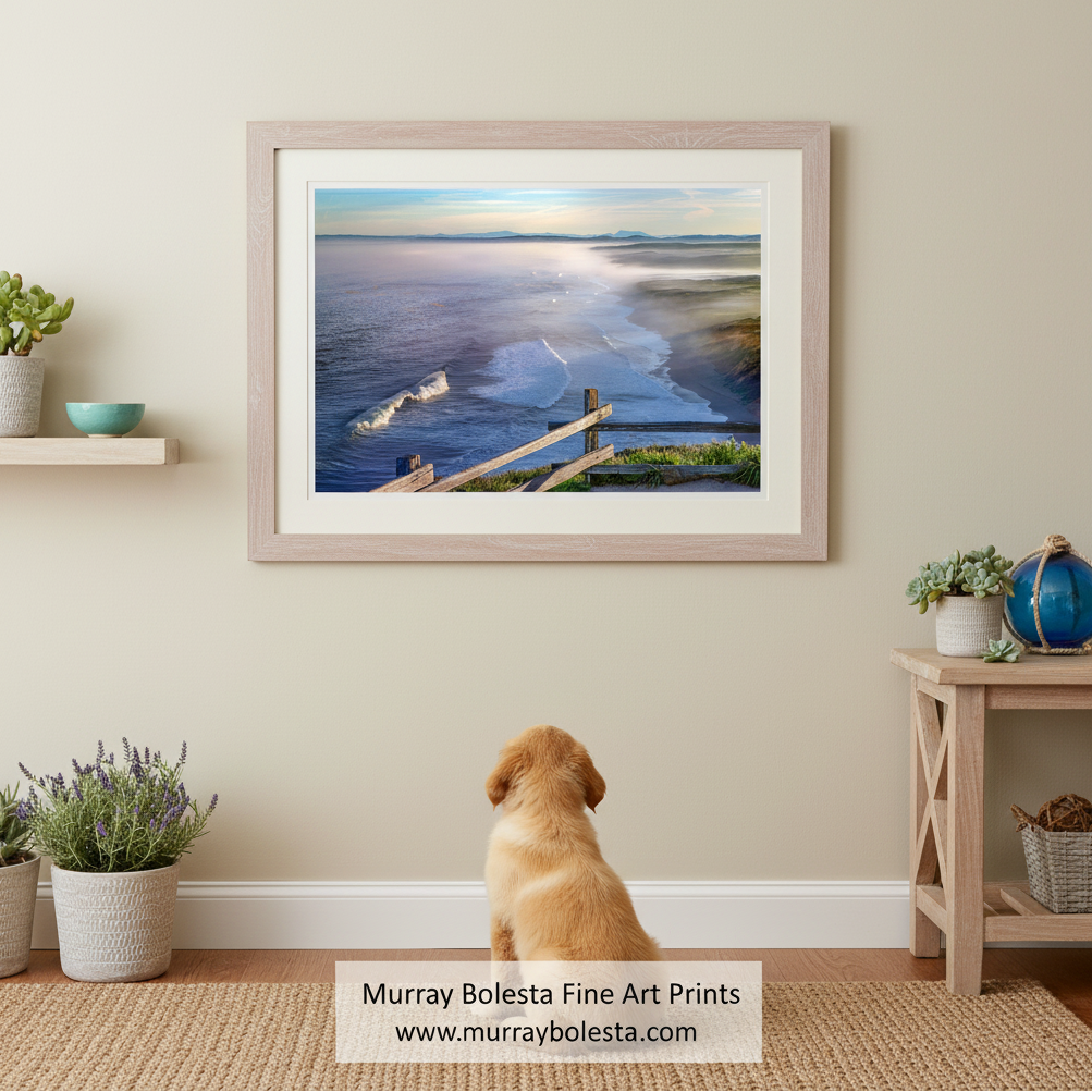 a serene coastal scene with a wooden fence overlooking the ocean. The fence is situated on a grassy hillside, providing a vantage point to admire the vast expanse of the ocean and the distant mountains. The sky above is a beautiful shade of blue, with a few clouds scattered across it, adding to the overall tranquility of the scene. Point Reyes Beach Seascape Art | Marin County California Print by Murray Bolesta!