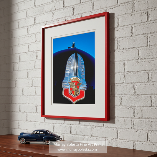 a close-up view of a vintage car emblem, which appears to be a shield-shaped emblem with a red and gold crest. Classic Cadillac Series 62 Vintage Car Art Print Wall Decor by Murray Bolesta