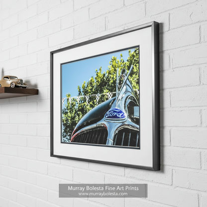 a close-up view of a classic Ford car's hood, featuring the iconic Ford emblem and grill. Vintage Ford V8 Old Car Picture as Wall Art by Murray Bolesta