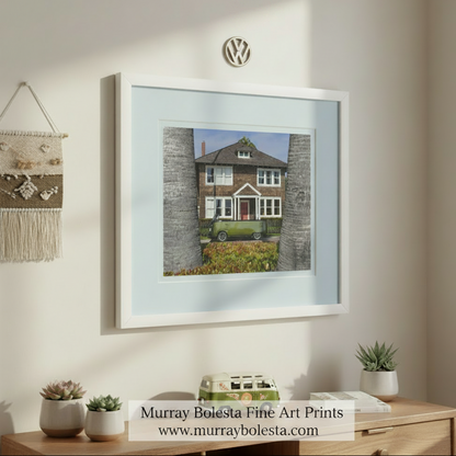 A two-story wooden house with a red door and white trim, surrounded by palm trees, with a green van parked in front of it. VW Bus Art – Custom Vintage Minivan Convertible Picture by Murray Bolesta