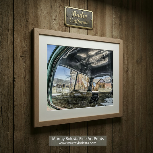 a dilapidated building with a large, broken window, and a bench in the foreground. Bodie Ghost Town Vintage Truck Wall Art - Rustic Western Decor by Murray Bolesta
