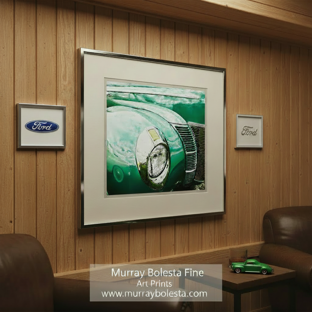 A close-up view of the front end of a vintage green car, showcasing its chrome grille and headlight. 1940 Ford Car Photo with Vintage Ford DeLuxe by Murray Bolesta