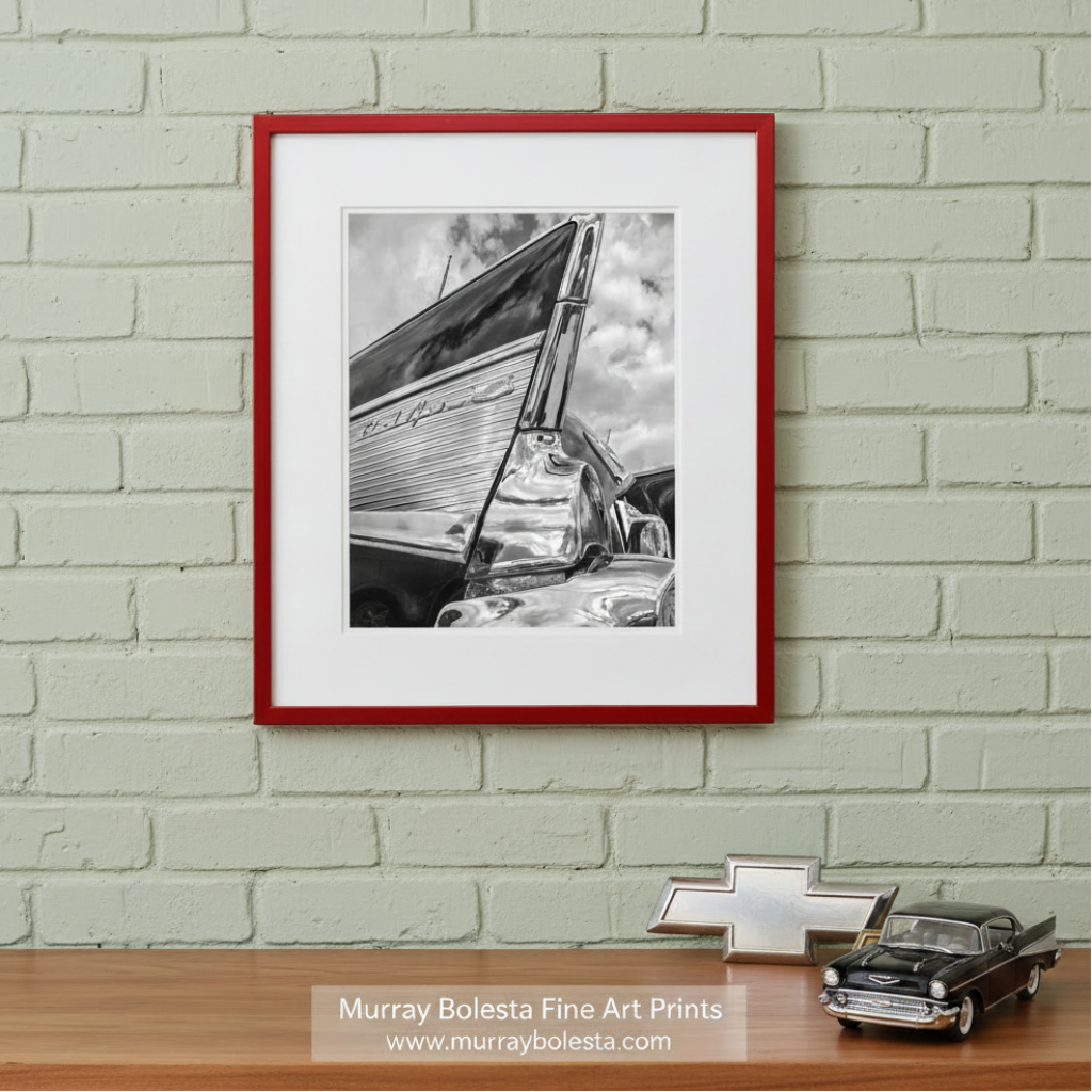 A black and white photograph of a chrome car, likely a classic or vintage vehicle, with a distinctive wing-like structure on the side. Chevy Bel Air Car Photo – Black & White Classic Chevrolet by Murray Bolesta