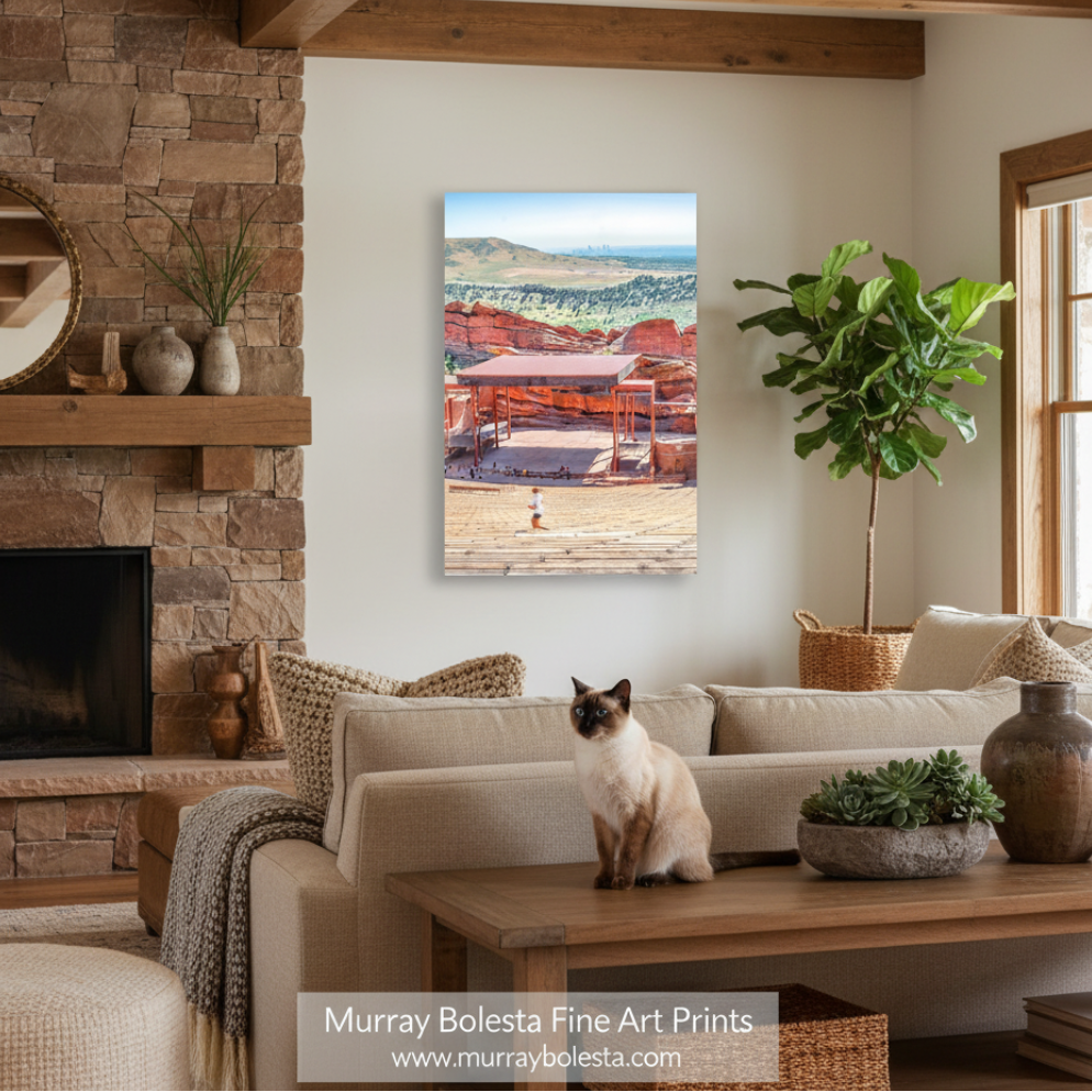 Denver Colorado Red Rocks Amphitheater by Murray Bolesta! A vertical canvas art print depicting a desert landscape with red rock structures and mountains, displayed on a wall in a modern living room setting with a cat on a sofa.