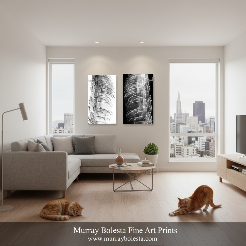A modern living room with a light gray sectional sofa, two black-and-white abstract wall art prints centered above the couch, large windows with a city skyline view, and two orange cats on the wood floor. A watermark at the bottom reads 'Murray Bolesta Fine Art Prints'.