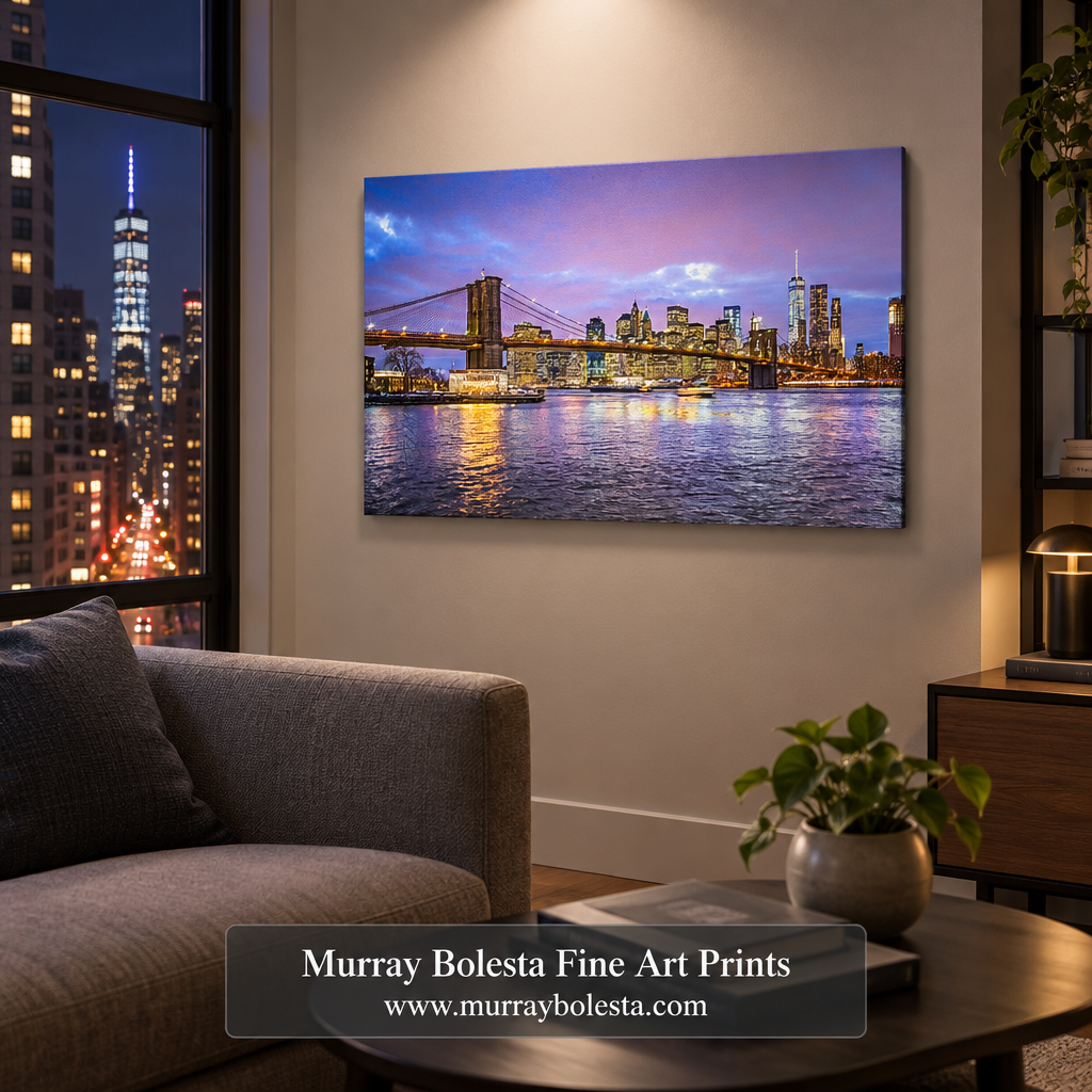A canvas wall art print depicting the Brooklyn Bridge and Manhattan skyline at dusk, displayed in a modern living room setting above a gray sofa. The print features a purple and pink sky with blue water reflections. Art by Murray Bolesta