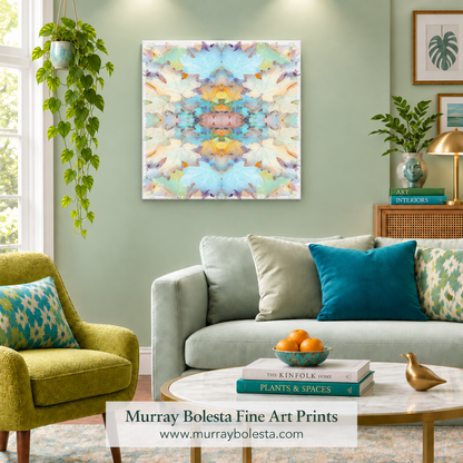A square abstract wall art print with a symmetrical pastel design hangs on a sage green living room wall above a light gray sofa with teal and patterned pillows. The scene includes a green armchair, coffee table, books, plants, and framed wall art. By Murray Bolesta.