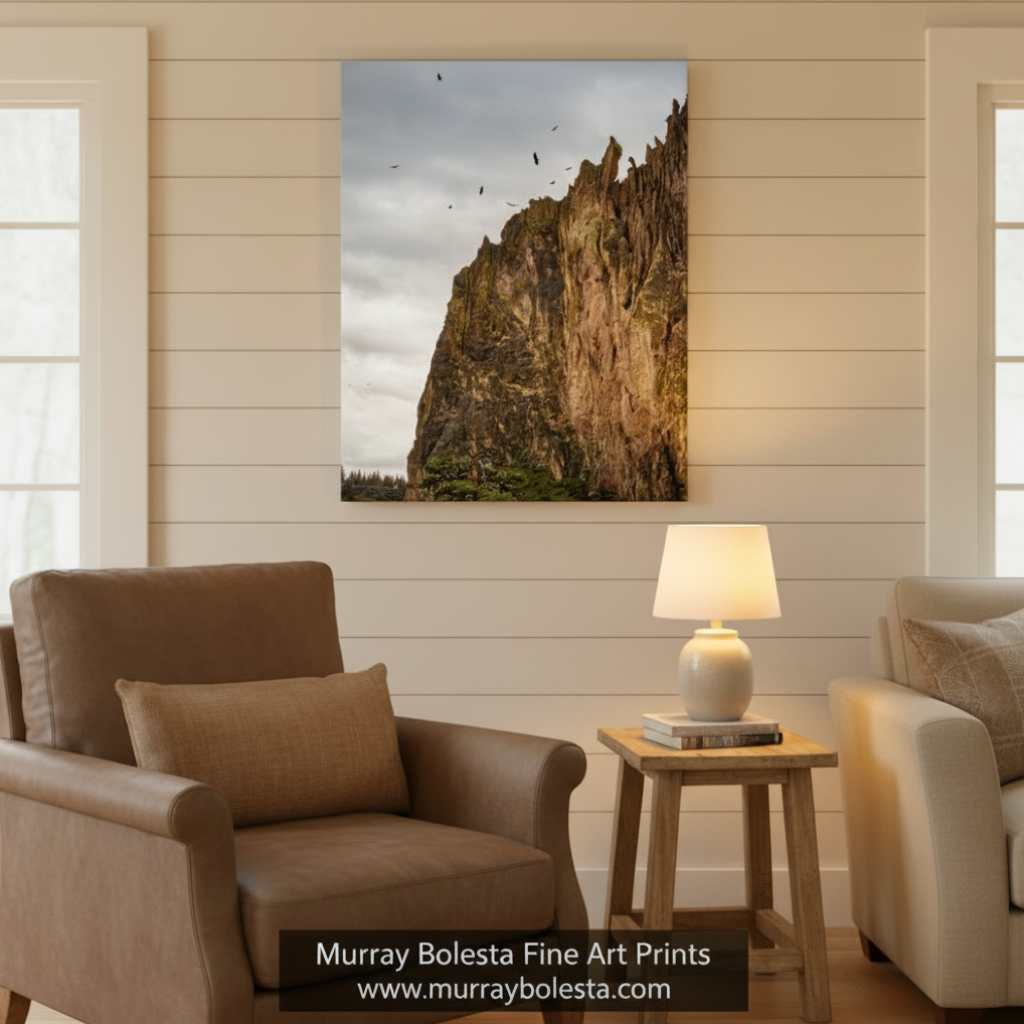 a rocky cliff with a flock of birds flying above it, set against a cloudy sky. Soaring Hawks at Smith Rock - Oregon Desert Landscape Bird Art Print by Murray Bolesta