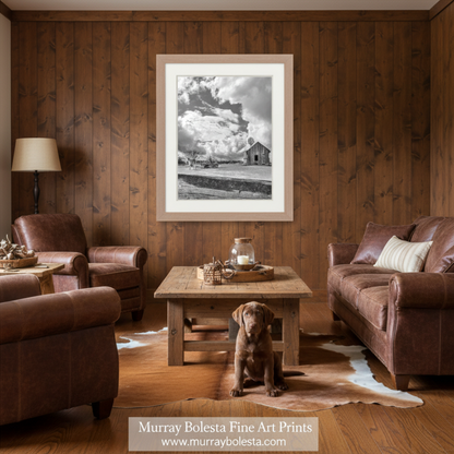 A black and white photograph depicting a wooden barn with a windmill on top, set against a cloudy sky. Horse Print Empire Ranch Corral | Black & White Equestrian Art by Murray Bolesta