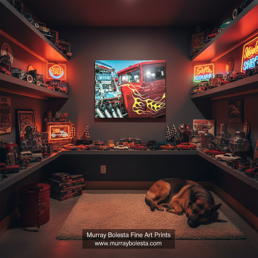 A framed wall art print depicting a red fire truck with yellow flames and a detailed engine, displayed in a dark home theater with toy cars, shelves, and a sleeping dog on a rug. A watermark at the bottom reads 'Murray Bolesta Fine Art Prints'.