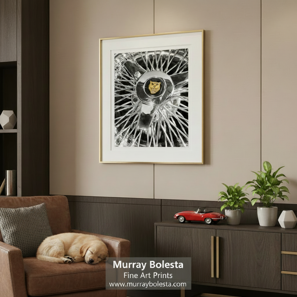 a close-up view of a chrome wheel with a prominent logo in the center. Jaguar Wire Wheel Art Print | Classic British Sports Car Decor by Murray Bolesta