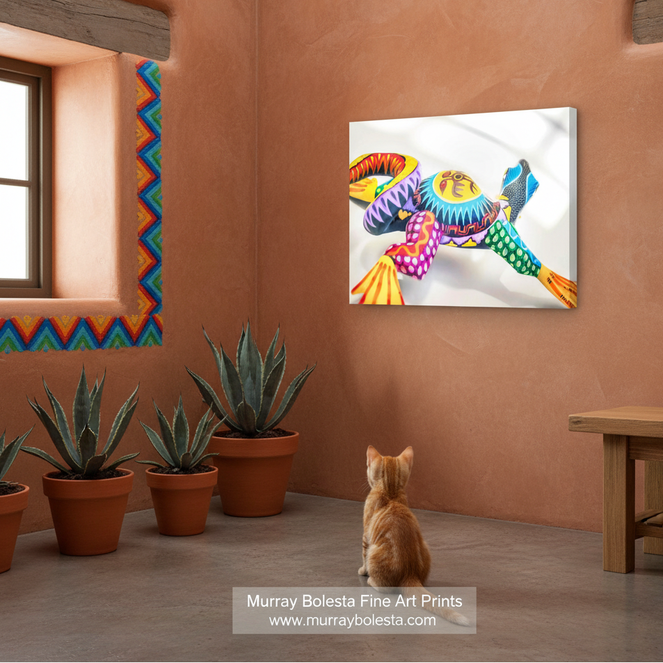 Oaxaca lizard by Murray Bolesta! A colorful wall art print depicting a stylized, vibrant bird with rainbow feathers, shown hanging on a terracotta-colored wall in a room with a cat sitting below it and potted plants.