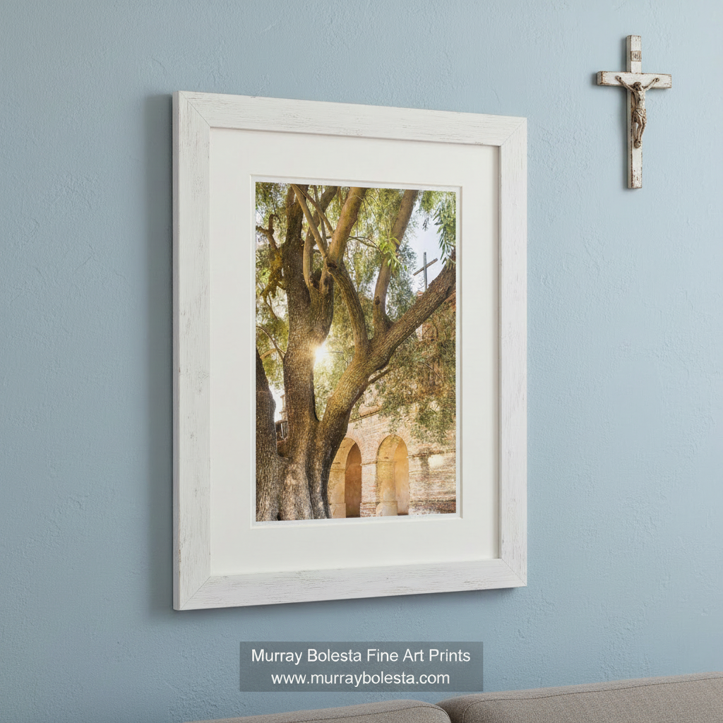 a large, gnarled tree with a cross on one of its branches, standing in front of a brick archway. Mission San Antonio de Padua Art - Lompoc California Church Print by Murray Bolesta