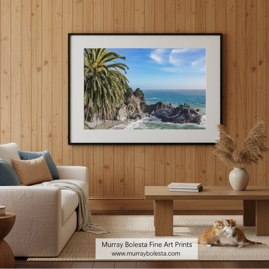 A picturesque coastal scene with a rocky shoreline, palm trees, and a clear blue sky with wispy clouds. McWay Falls Beach Art Print Big Sur California Coast Photography by Murray Bolesta!