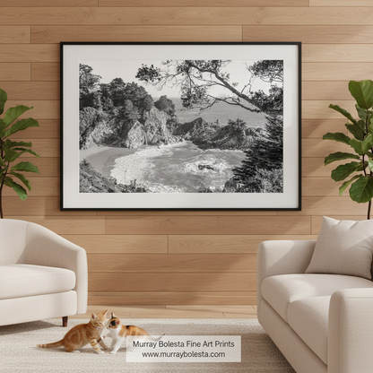 A black and white photograph depicting a rocky coastline with crashing waves, a sandy beach, and a distant body of water. McWay Falls Big Sur Black & White Art Print | California Coast Photo by Murray Bolesta!