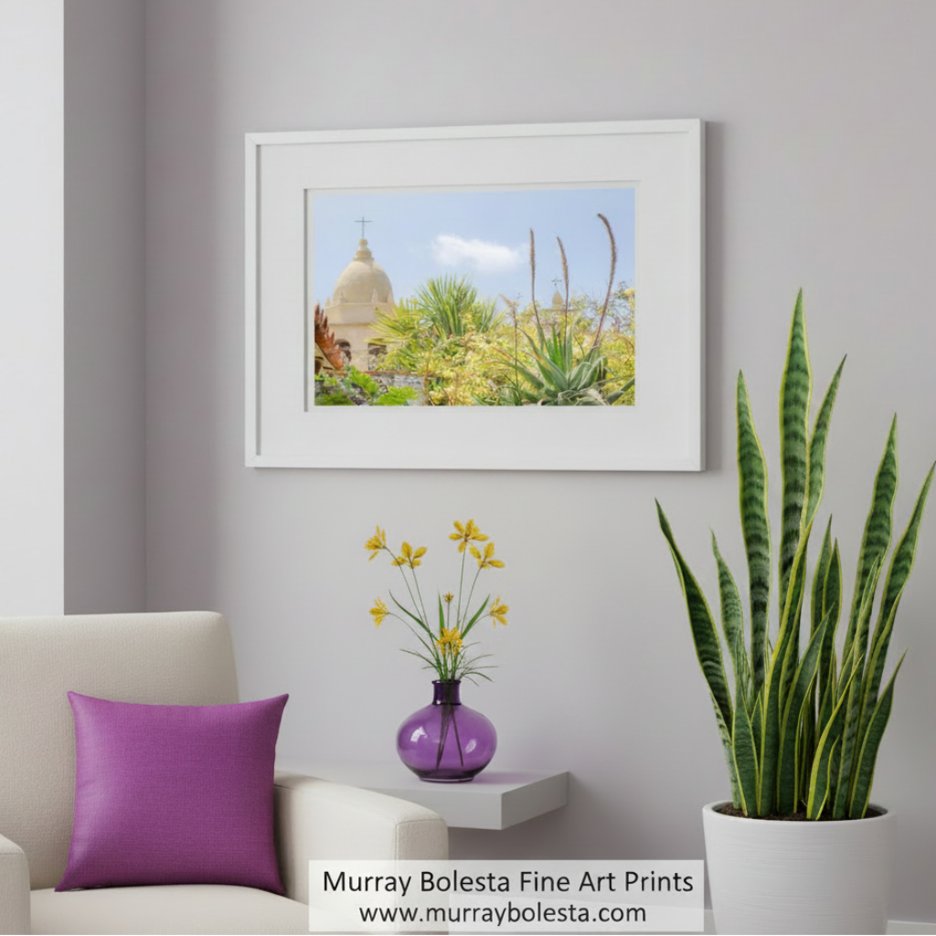 a serene landscape with a large dome-shaped building, a cross on top, and lush greenery surrounding it. Carmel Mission Church Art Print – Spanish Colonial Architecture Photo by Murray Bolesta