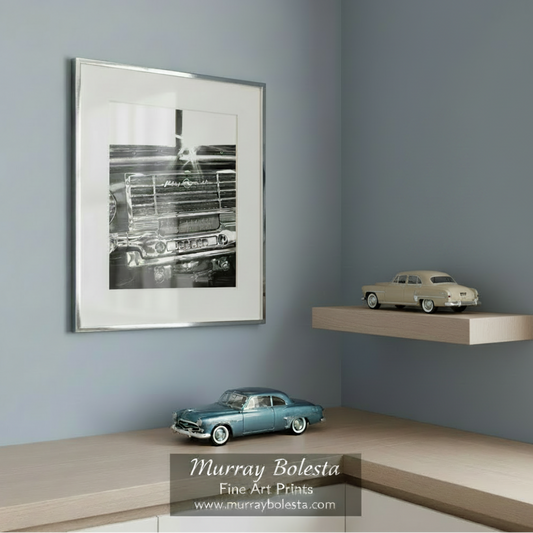 A black and white photograph of the front end of a classic Plymouth car, with the brand name prominently displayed on the grille. Plymouth Car Picture as Vintage Automobile Wall Art by Murray Bolesta