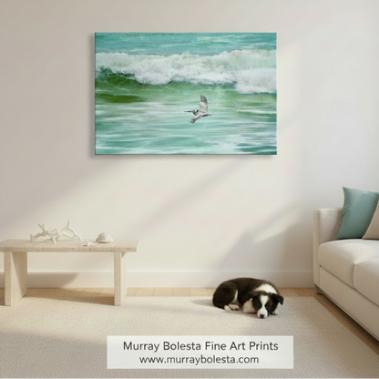 A pelican soars above the ocean waves, its wings spread wide as it glides effortlessly through the air. Pelican in Flight Art | San Diego Beach Seabird Framed Print by Murray Bolesta!