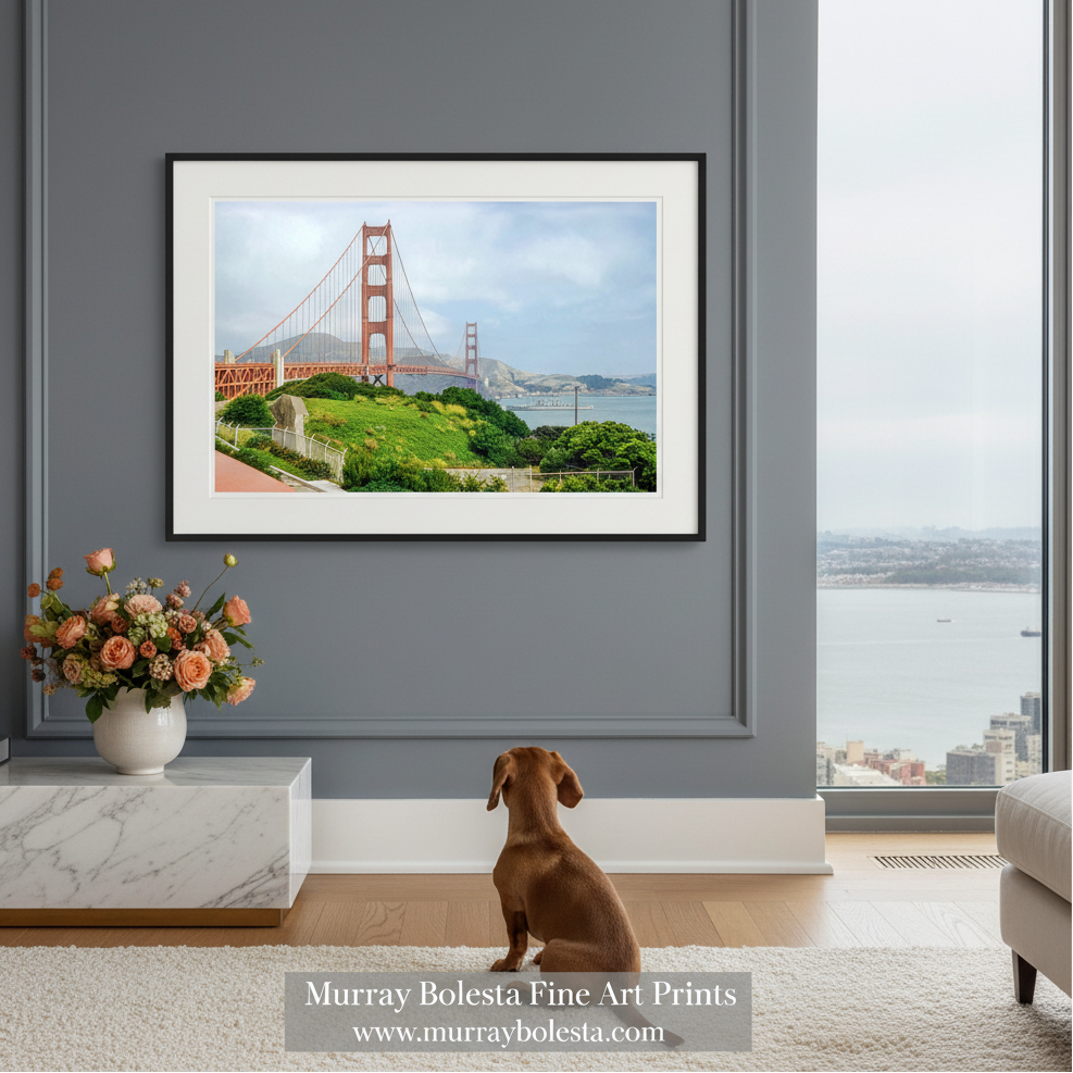 the iconic Golden Gate Bridge spanning across a body of water, with lush greenery and a cloudy sky in the background. Golden Gate Bridge & Warship Vintage Photo – San Francisco Art, Presented by Murray Bolesta