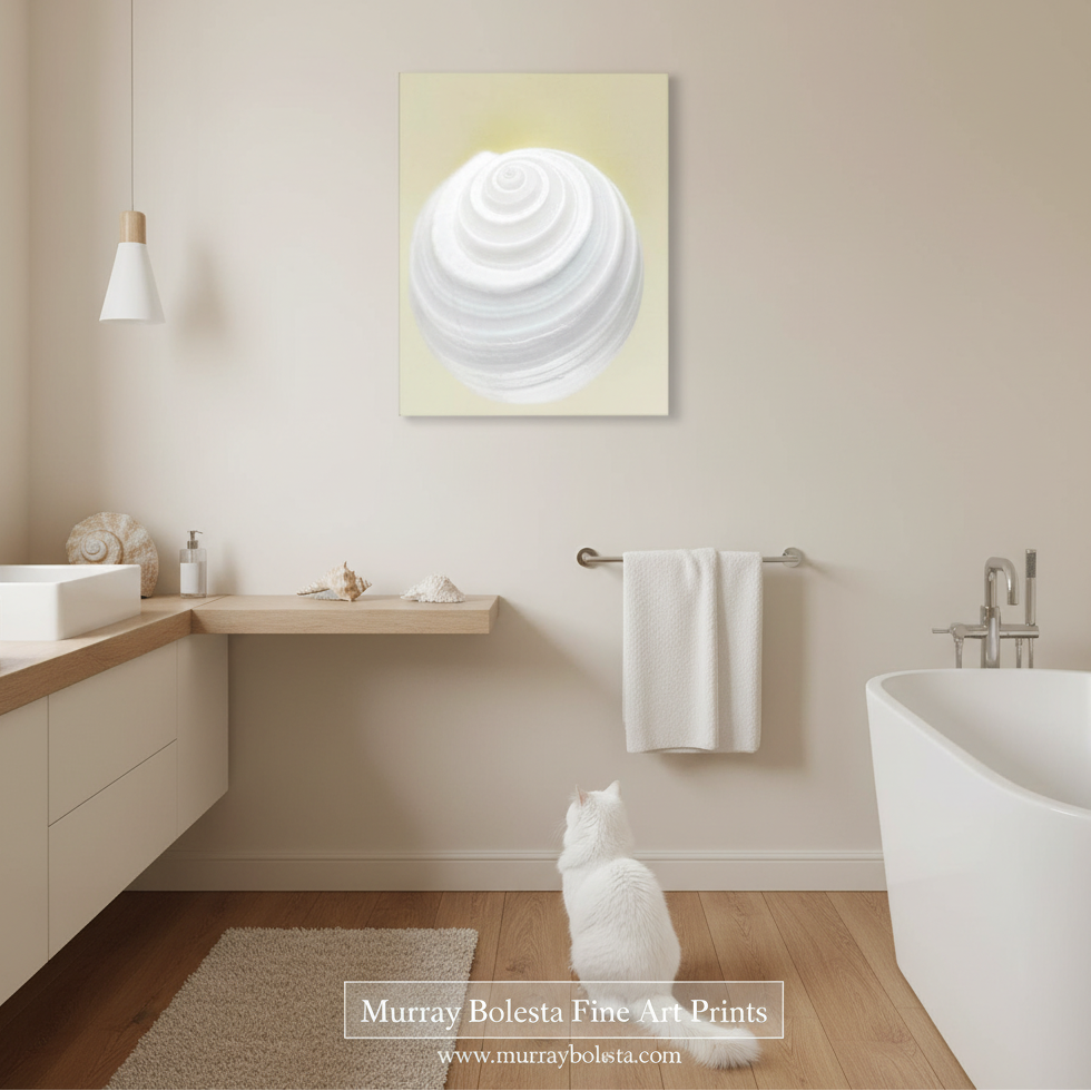 By Murray BolestaA white spiral shell art print on a pale yellow background, displayed on a beige wall in a modern bathroom with a white cat sitting below it. 