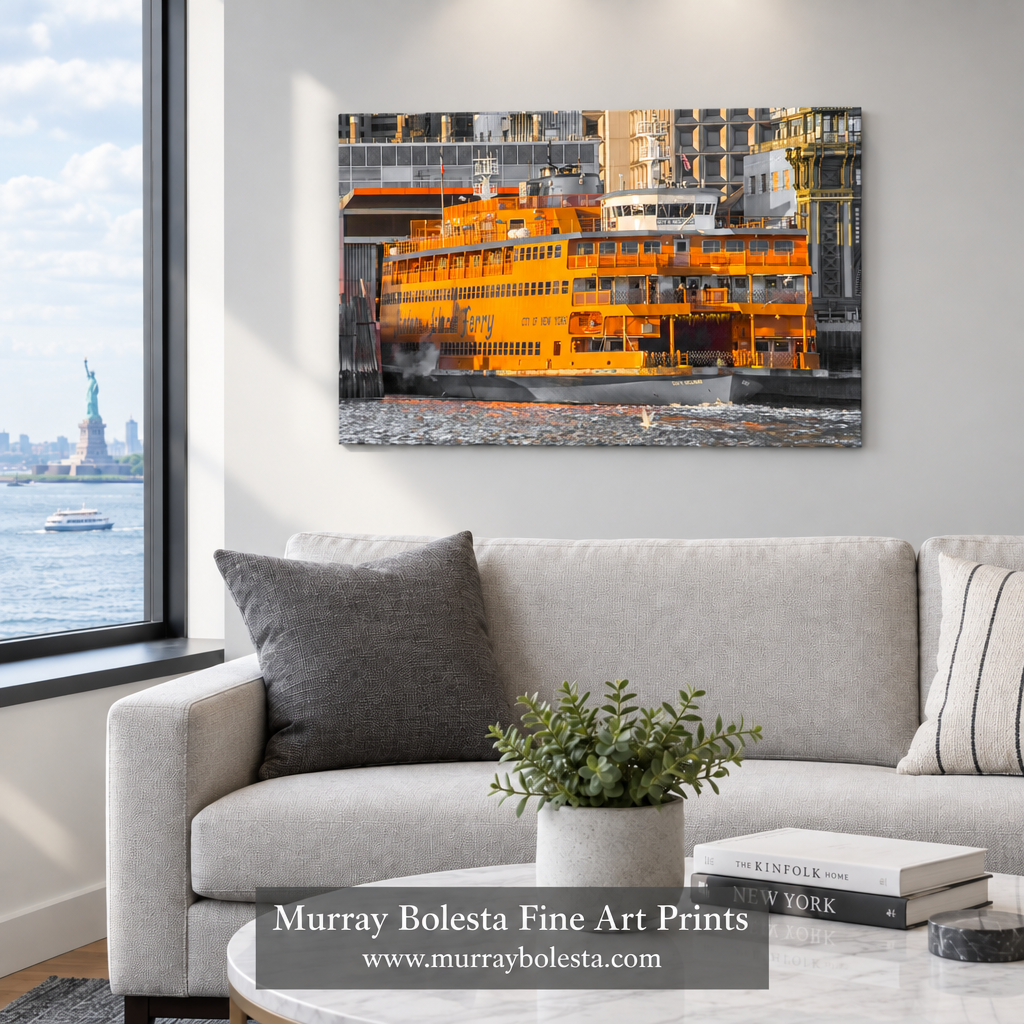 A framed wall art print showing an orange ferry by the water, displayed above a light gray sofa in a modern living room. The print is the product being sold, and the room serves as a lifestyle mockup context. Staten Island Ferry by Murray Bolesta