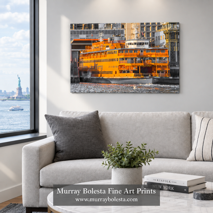 A framed wall art print showing an orange ferry by the water, displayed above a light gray sofa in a modern living room. The print is the product being sold, and the room serves as a lifestyle mockup context. Staten Island Ferry by Murray Bolesta