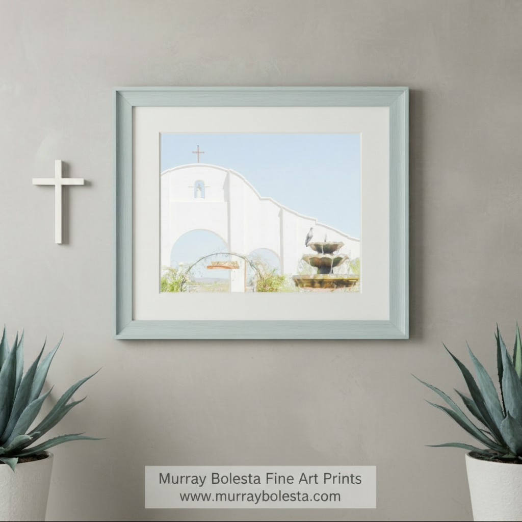 a white church with a cross on top, surrounded by a fountain and a bird perched on a nearby structure. San Xavier Southwest Mission Architecture Art - Tucson AZ Print by Murray Bolesta
