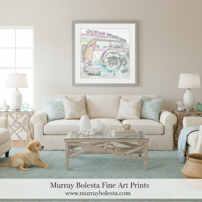 A framed art print featuring a colorful retro beach bus illustration with the words 'Ocean Beach' hangs on a beige wall above a cream sofa in a styled living room. A small golden puppy is lying on a light blue rug at the bottom left.